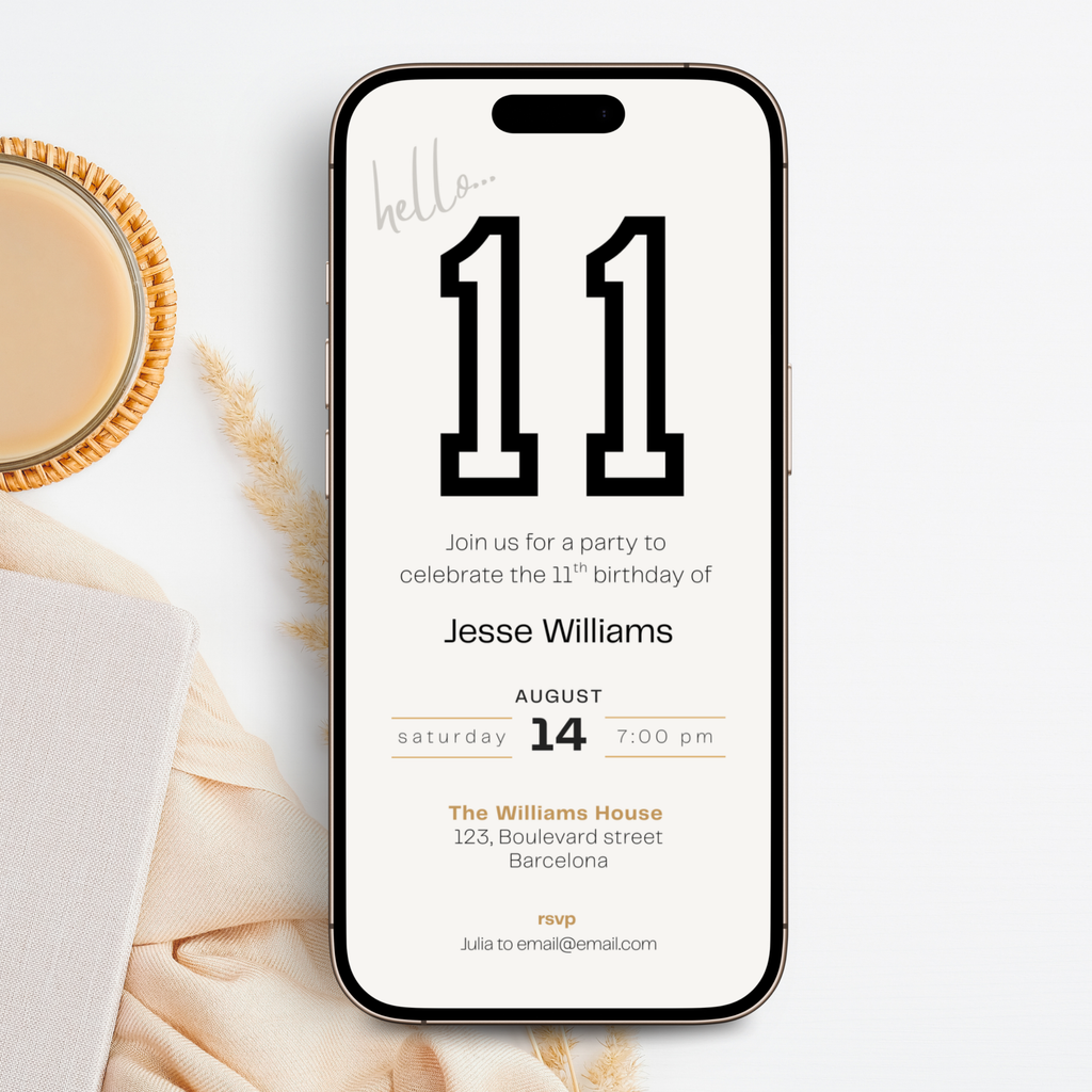 Phone displaying a 11th birthday invitation with 'hello 11' design, placed on a marble surface with a cup of coffee.