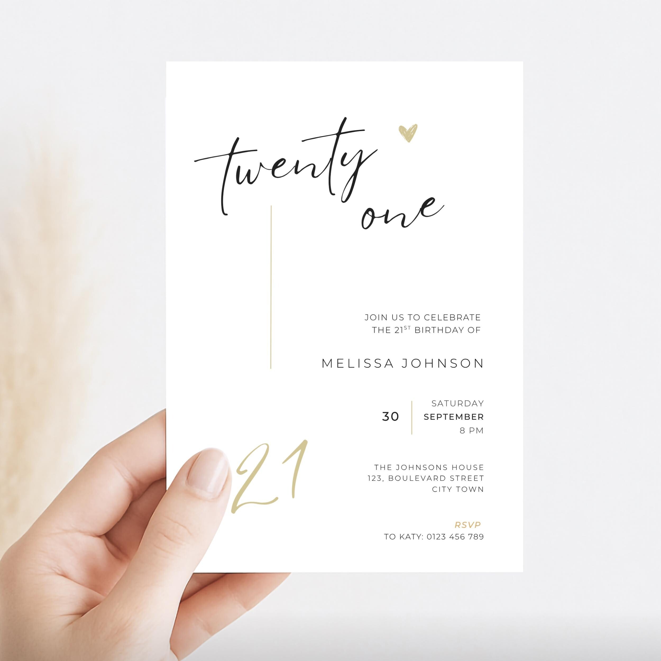 Hand holding a 21st birthday invitation card with gold and black text on a white background