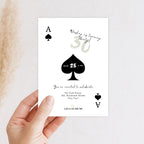Hand holding a playing card-themed birthday invitation with spade symbols and text.