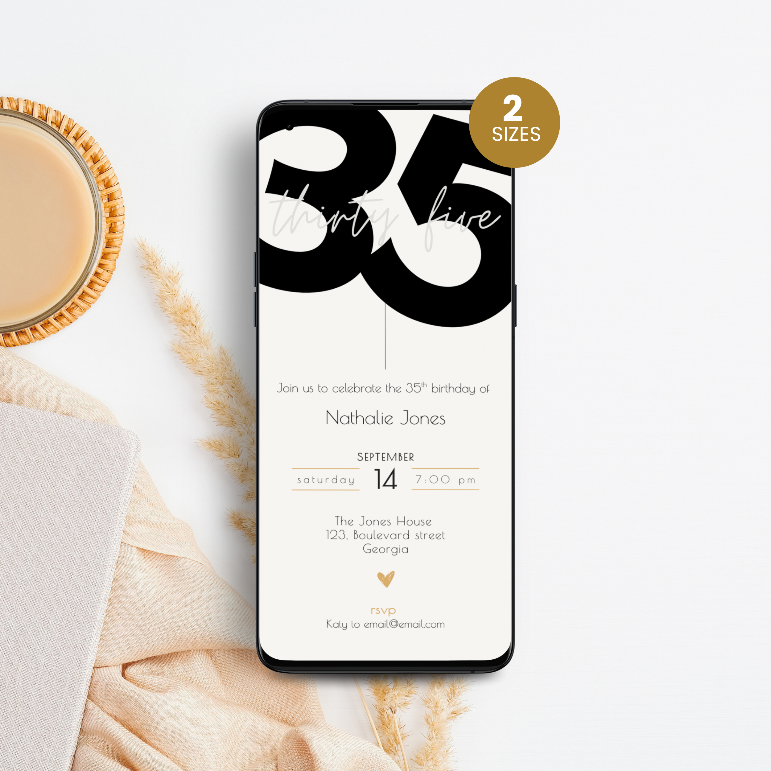 Phone displaying a 35th birthday invitation with '35' on a white surface with a cup of coffee.