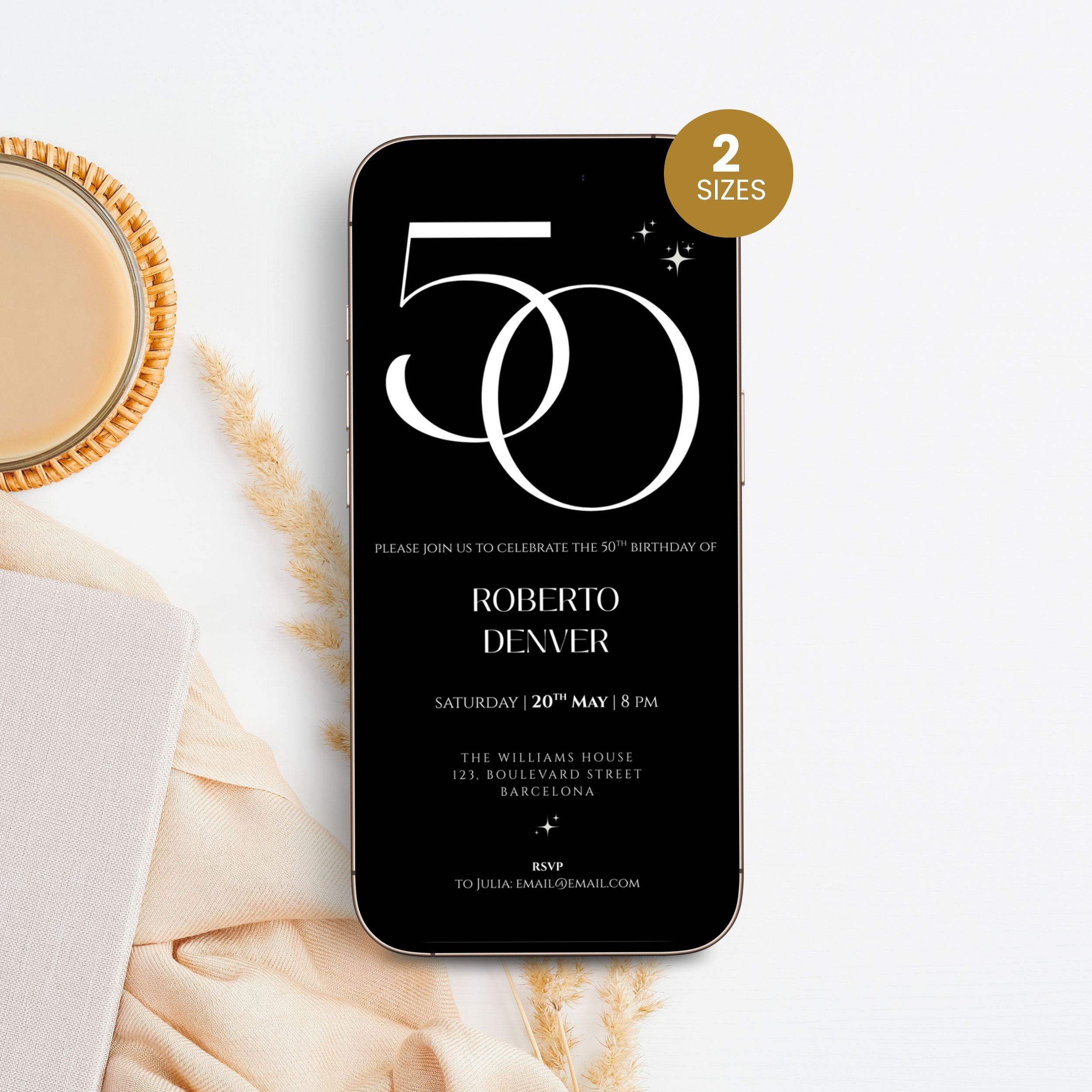Phone displaying a 50th birthday invitation with '50' design, placed on a marble surface with a cup of coffee.