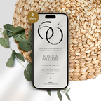 Phone with a 60th birthday invitation on a woven mat with eucalyptus leaves