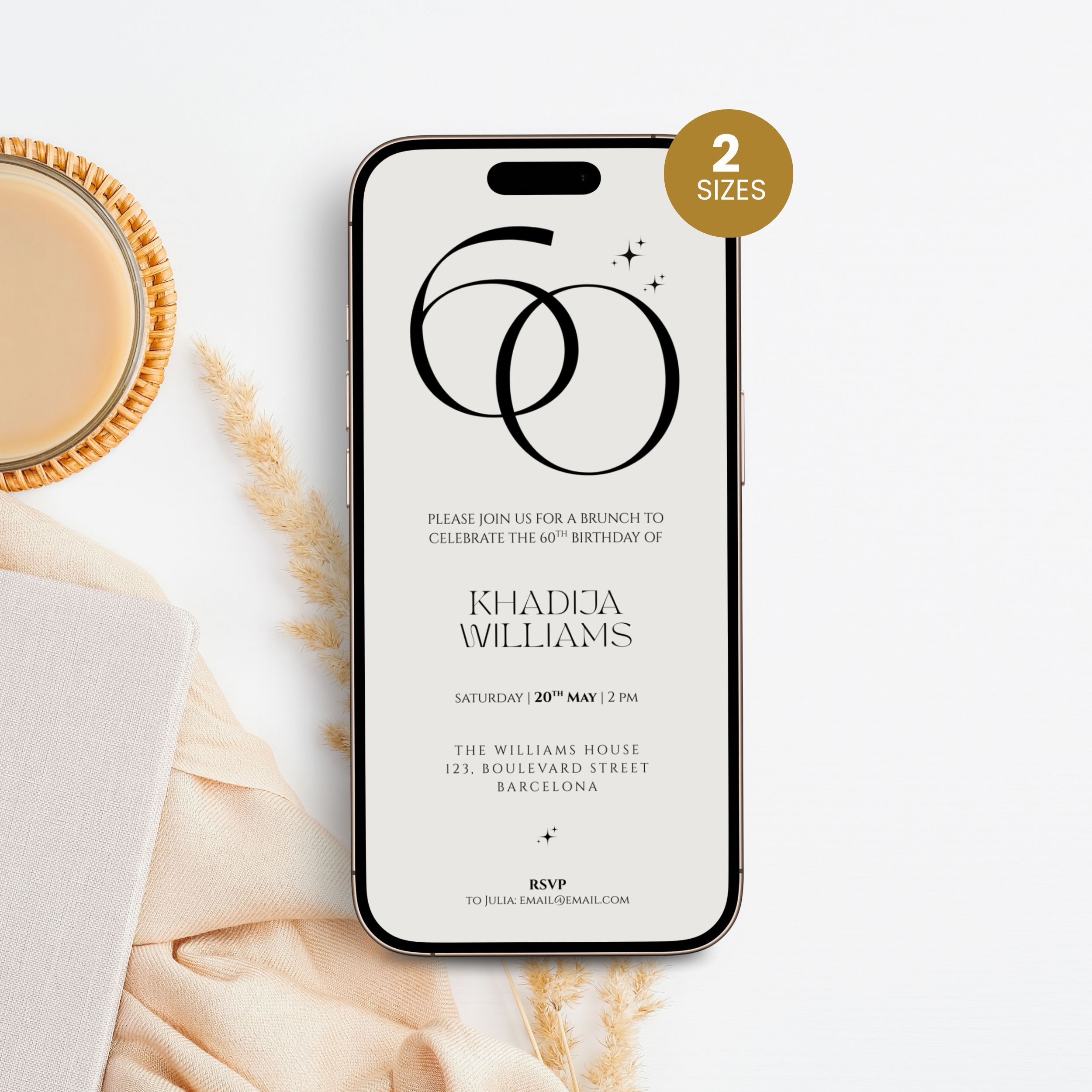 Phone displaying a 60th birthday invitation with a cup of coffee and decorative elements on a white surface