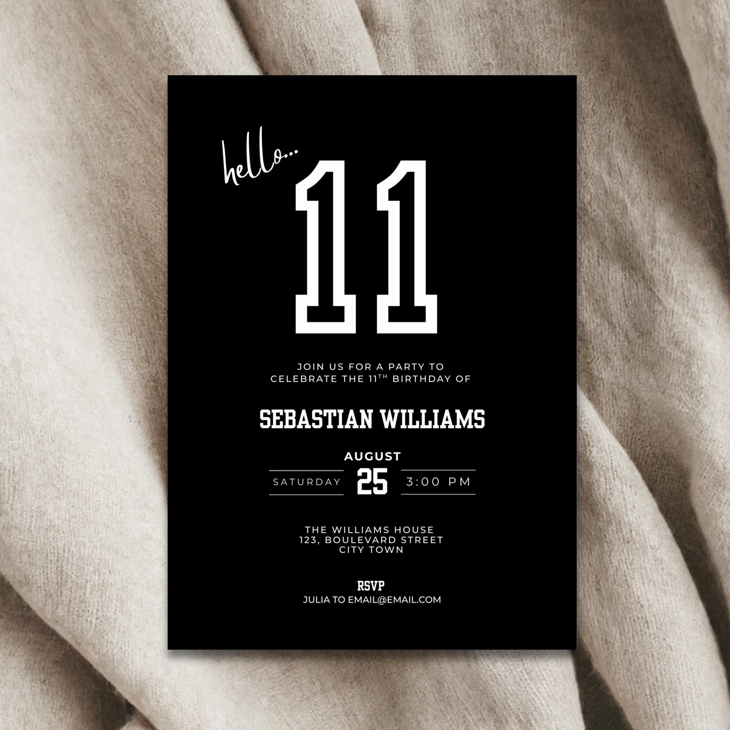Black birthday invitation card with white text on a beige fabric background
