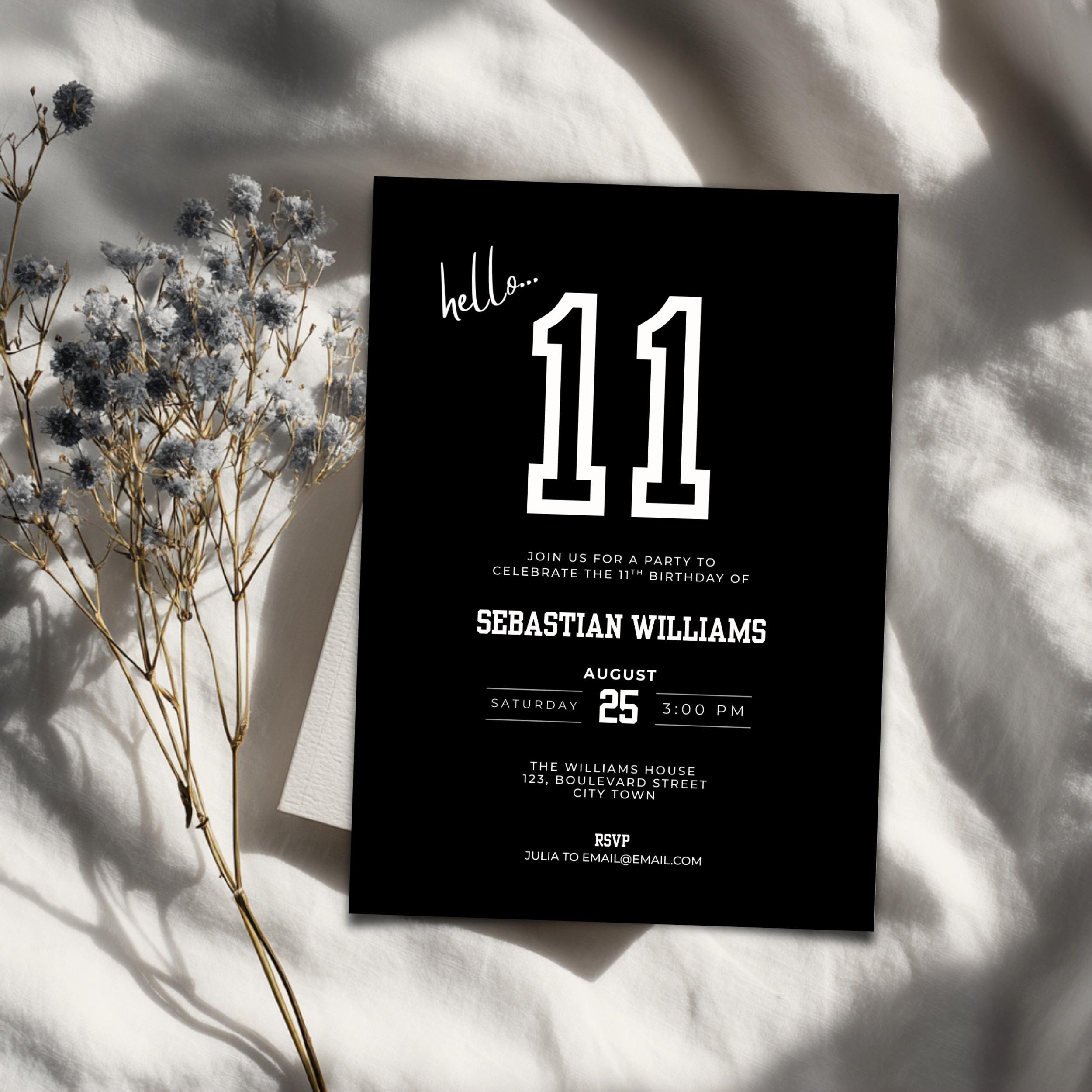 Black 11th birthday invitation card with white text on a light fabric background