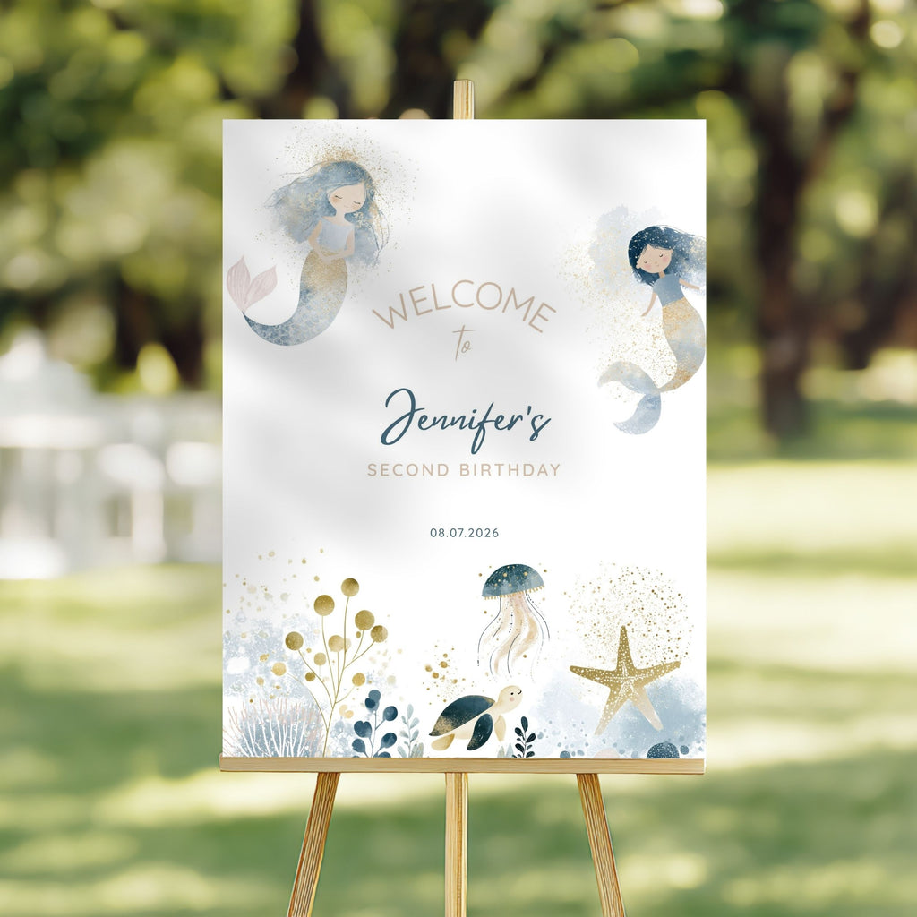A vertical wedding or birthday welcome sign on a wooden easel, featuring a white background with watercolor mermaids, sea creatures, and gold decorative text reading 'Welcome to Jennifer's Second Birthday' and the date '08.07.