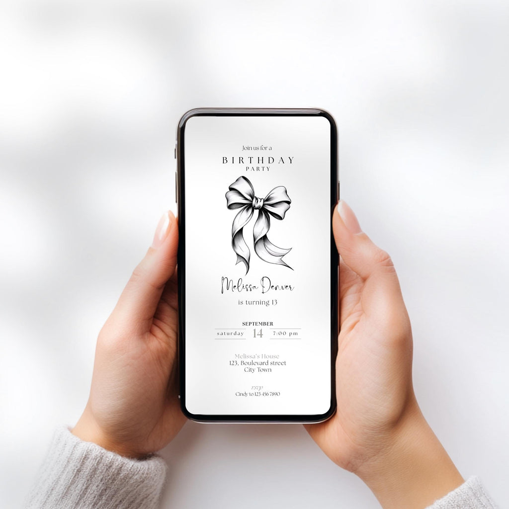 Person holding a smartphone with a birthday party invitation on the screen against a light gray background