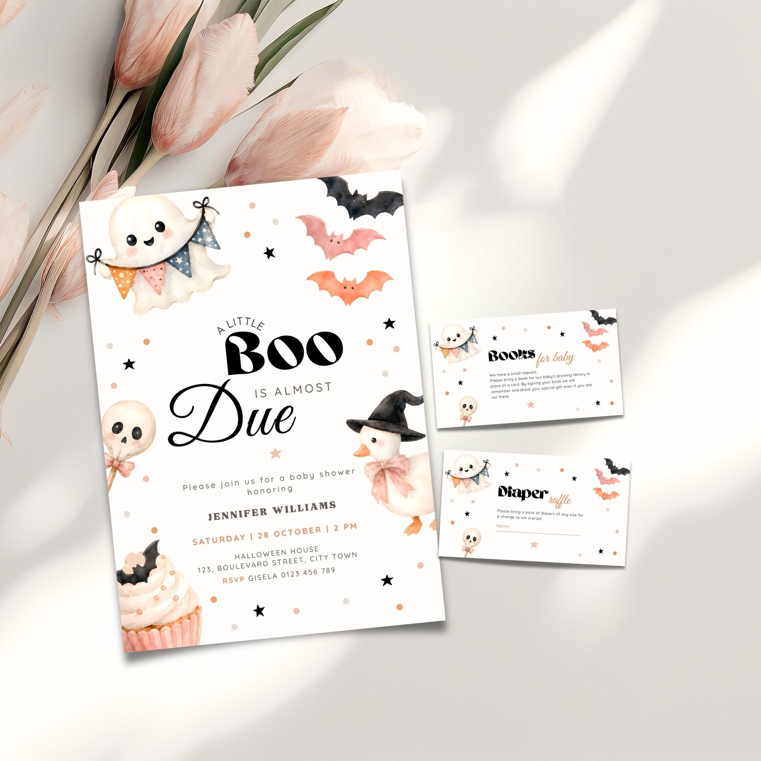A Halloween little boo baby shower invitation set styled on a light surface with pink tulips. The main invitation card reads 'A Little Boo Is Almost Due' with cute ghost, bat, witch, and cupcake illustrations.