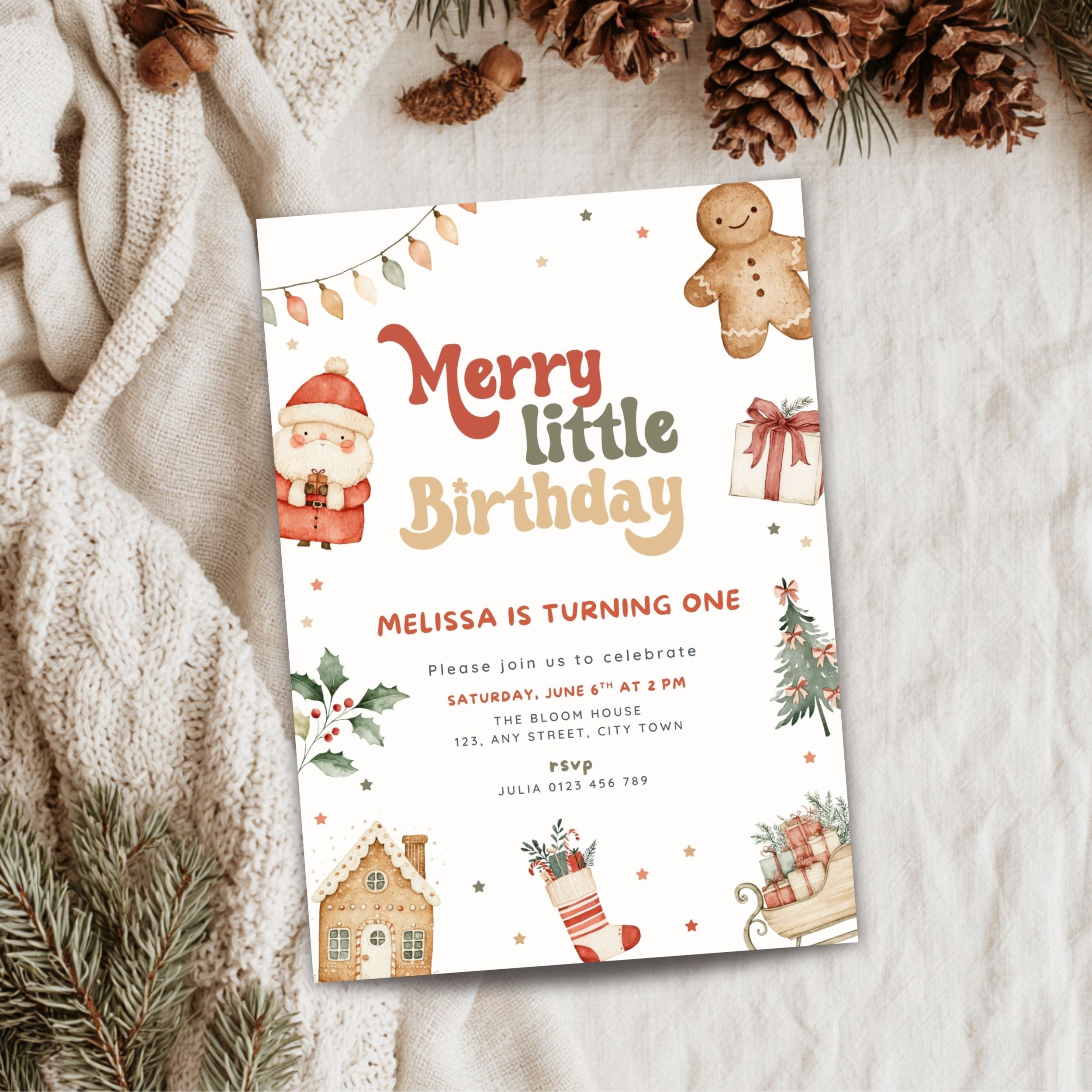 A festive Christmas-themed birthday invitation card styled in a flat-lay arrangement with a cozy beige knit sweater, pinecones, and evergreen branches on a soft white fabric background.