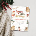 A festive Christmas-themed birthday invitation card styled in a flat-lay arrangement on a textured cream knit blanket with red berries and green pine branches. The card features a white background decorated with illustrations of a gingerbread man, Santa Claus, a gingerbread house, a Christmas tree, a sleigh, and the text 'Merry little Birthday' and 'Melissa is turning one'.