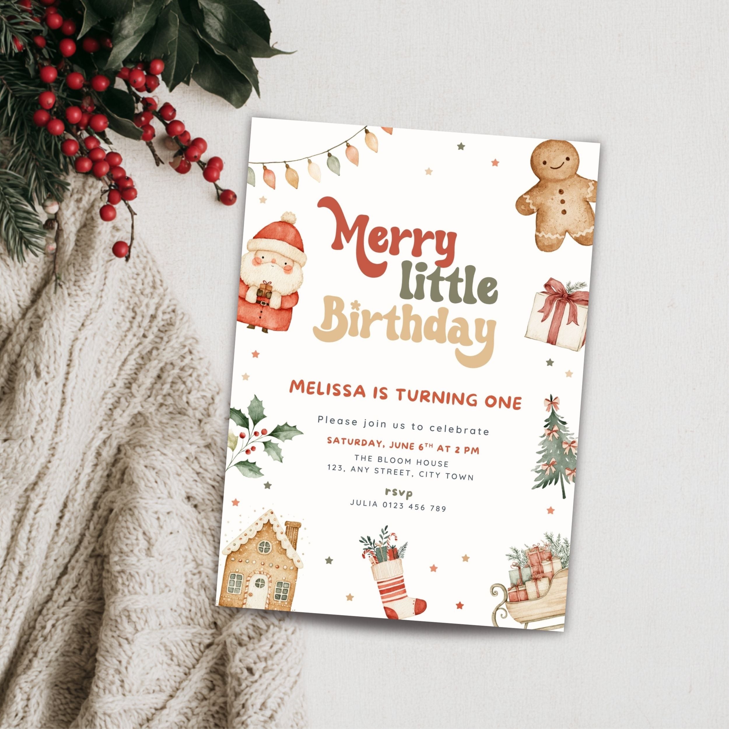 A festive Christmas-themed birthday invitation card styled in a flat-lay arrangement on a textured cream knit blanket with red berries and green pine branches. The card features a white background decorated with illustrations of a gingerbread man, Santa Claus, a gingerbread house, a Christmas tree, a sleigh, and the text 'Merry little Birthday' and 'Melissa is turning one'.