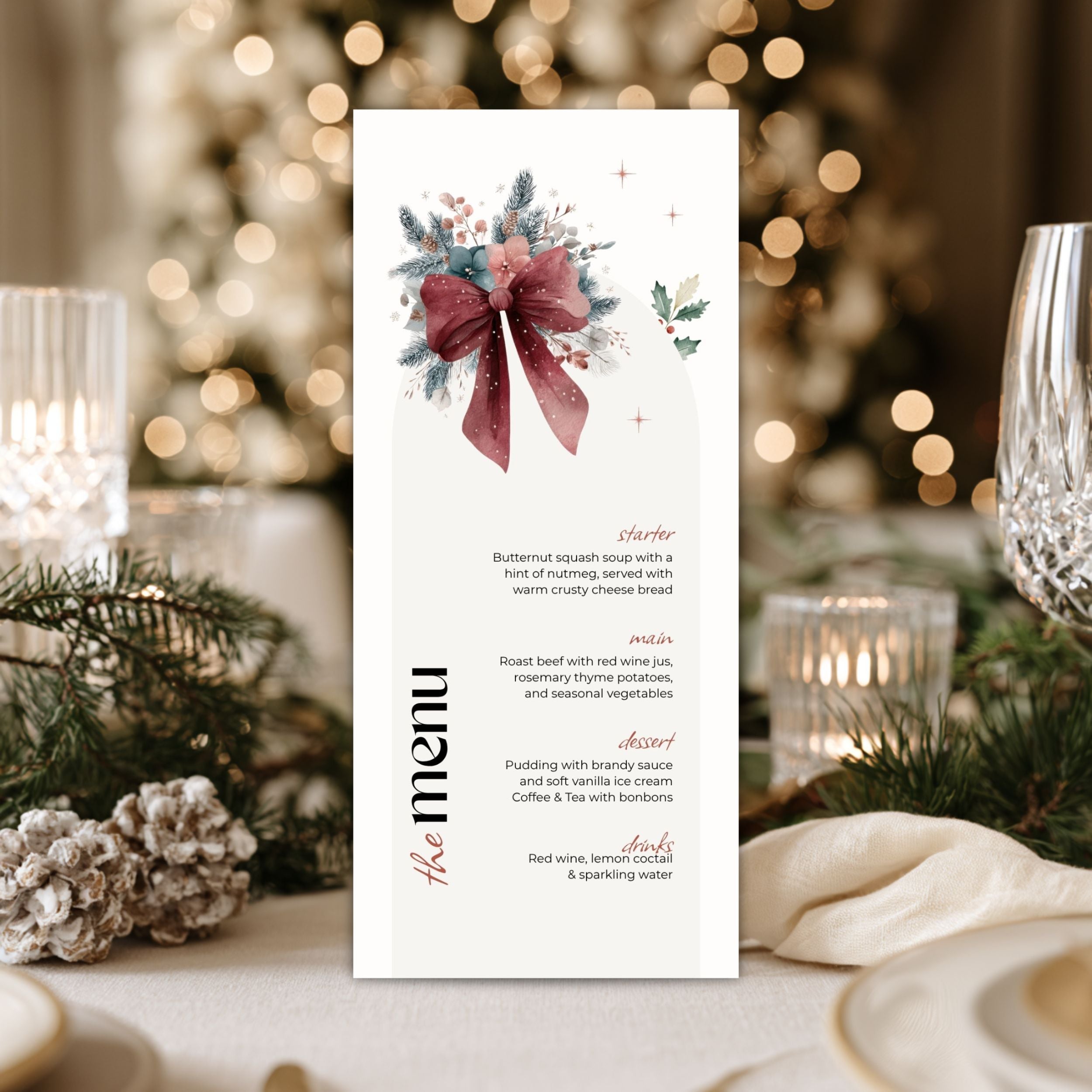 A vertical chrsistmas menu card with a watercolor floral and bow illustration at the top, styled on a table with candles, plates, pine branches, and a blurred Christmas tree in the background.