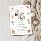 A festive Christmas-themed birthday invitation card for Wesley, styled on a light wood surface next to a cozy beige knit sweater and gold ornaments.