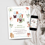 A festive Christmas-themed birthday invitation card for Wesley's first birthday, styled in a flat lay next to a smartphone displaying the digital version of the design. The card features colorful text reading 'OH WHAT FUN', a light blue border, illustrations of a snowman, gingerbread man, Santa hat, and a gift, set against a cozy background of a white knit blanket and pinecones.