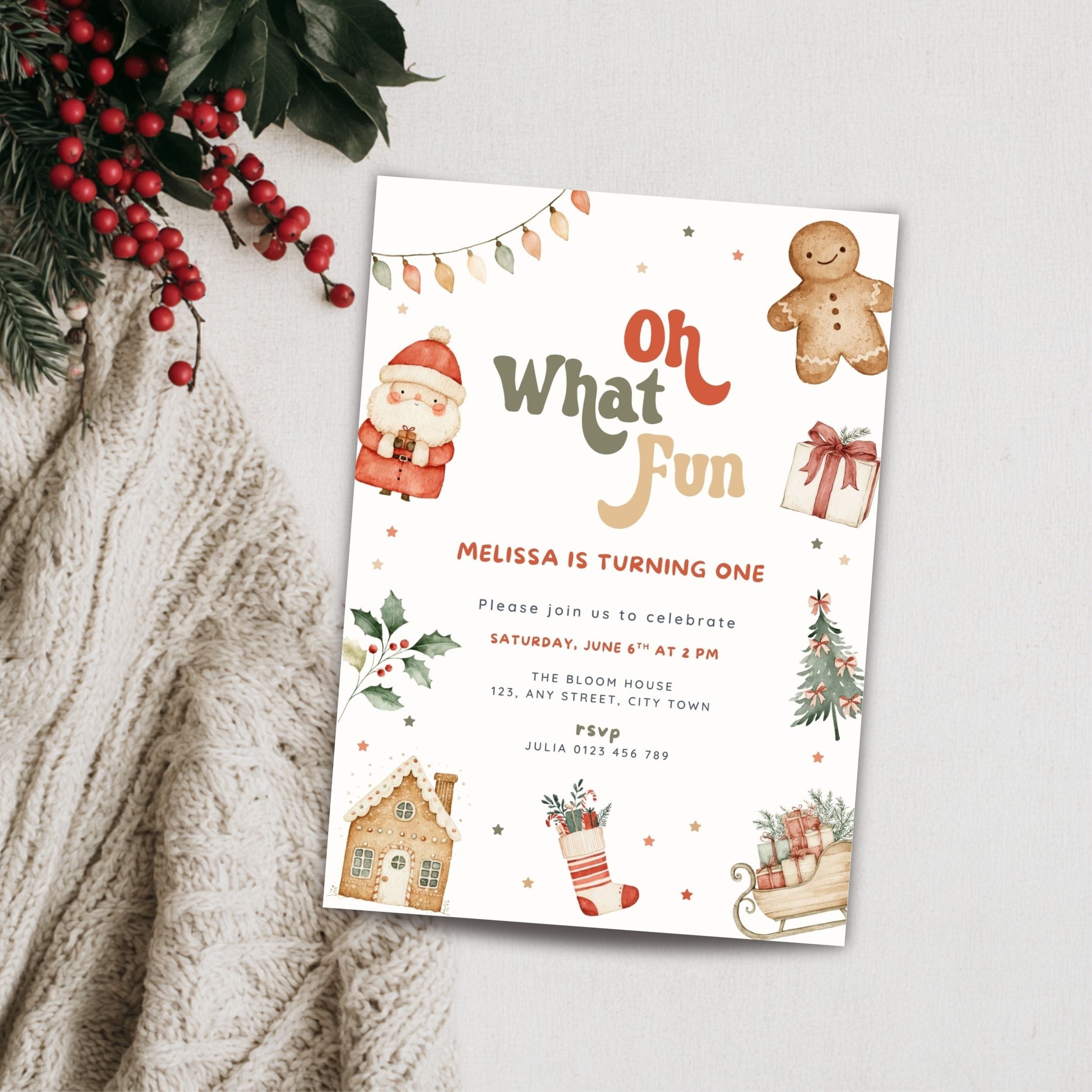 A Christmas-themed birthday invitation card styled on a light gray surface with a knitted cream sweater and red berries in the corner. The card features festive illustrations including a gingerbread man, Santa, a Christmas tree, a stocking, and the text 'Oh What Fun' and a birthday celebration invitation.