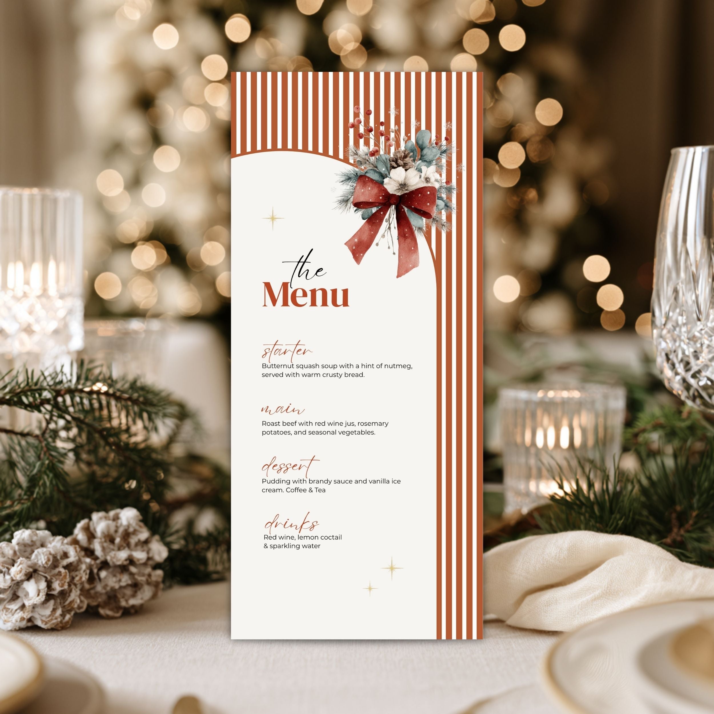 A festive Christmas-themed wedding menu card displayed on a beautifully styled table setting with a blurred Christmas tree in the background.