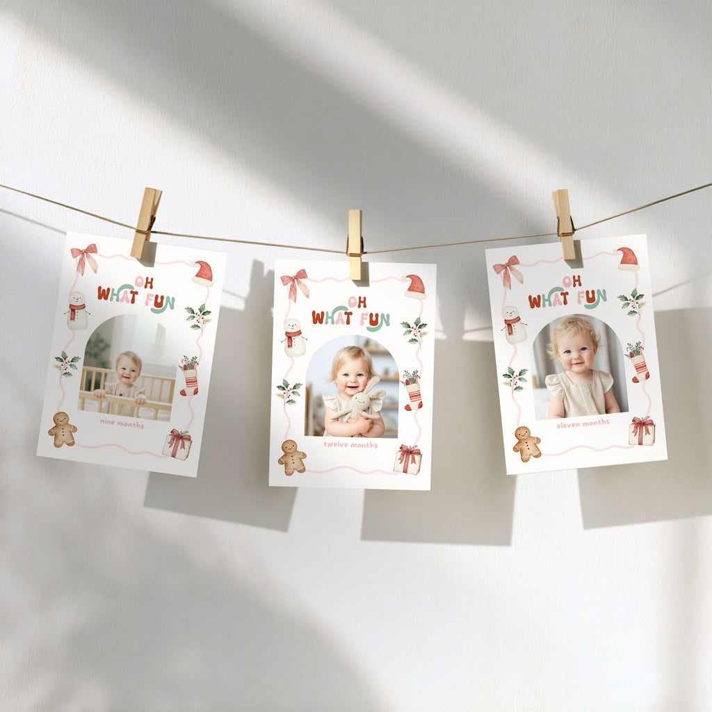 Christmas monthly photo banner featuring a baby photo in an arched frame, with a watercolor snowman, gingerbread cookie, Christmas stocking, Santa hat, holly, presents, and pink decorative border.