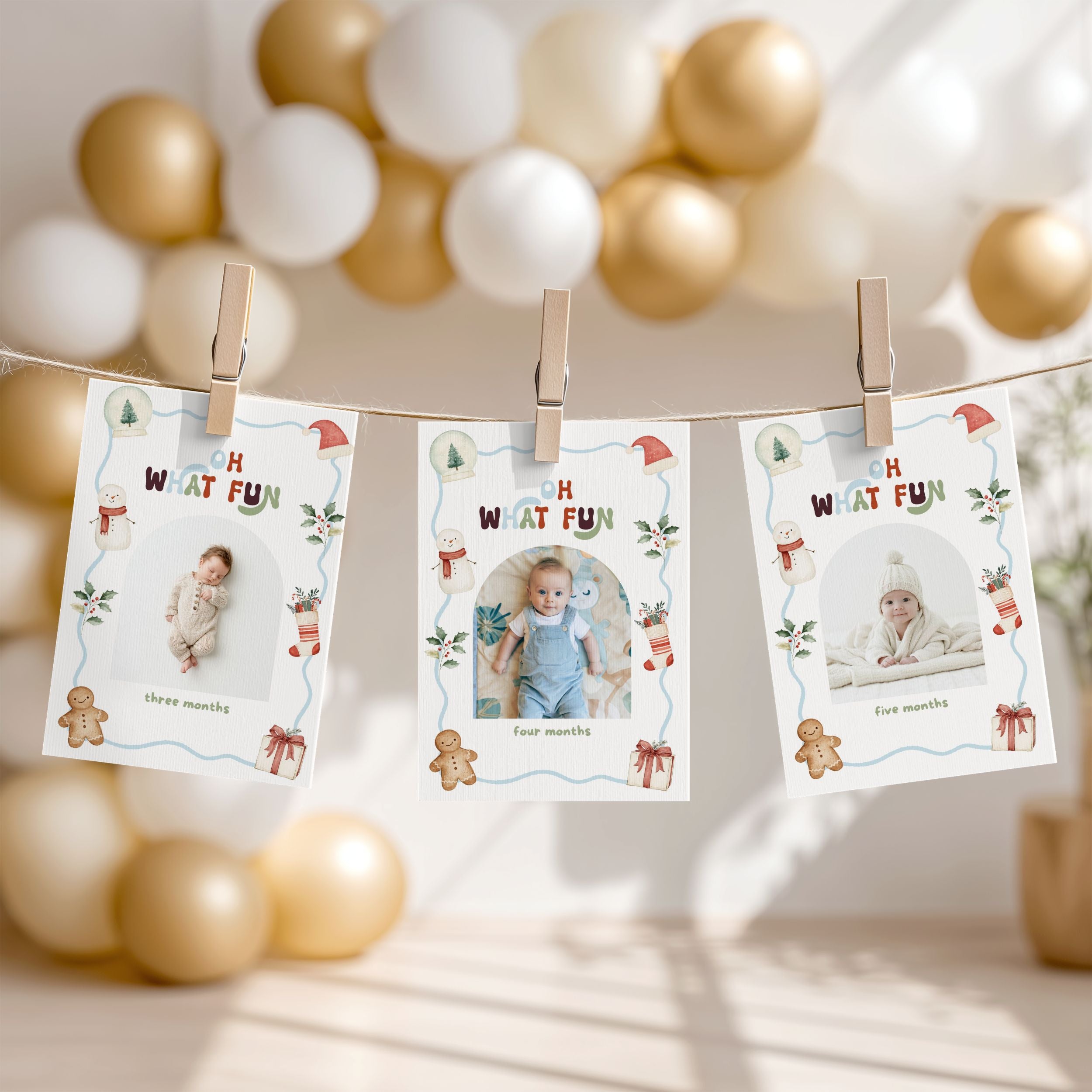 Three printed baby milestone photos clipped to a string banner with wooden clothespins, shown in a softly lit nursery-like setting with gold and white balloons in the background.