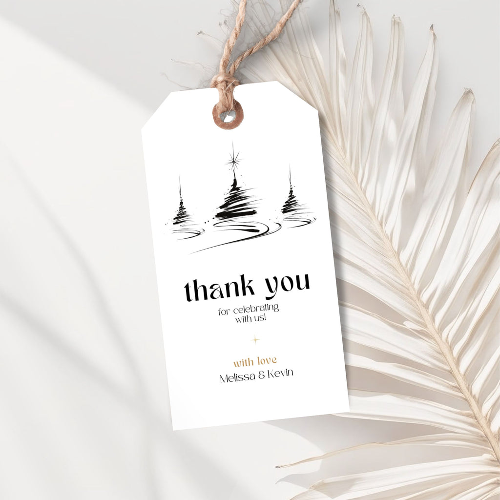 White personalized Christmas thank you gift tag template with a twine loop and black tree illustrations, styled with dried palm leaves