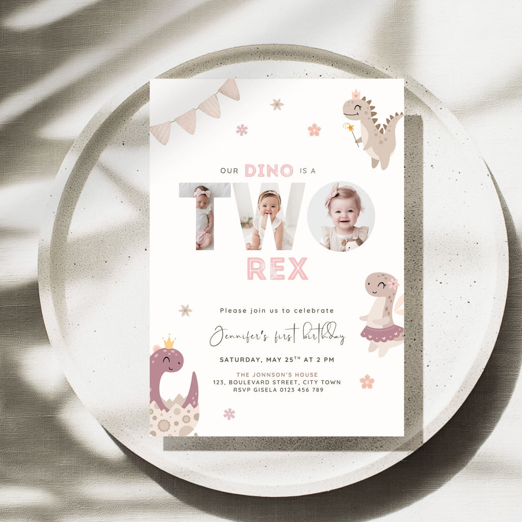 A baby dinosaur-themed 2nd birthday invitation card displayed on a speckled white plate with soft shadows. The card features cute illustrations of dinosaurs, stars, and text reading 'OUR DINO IS A TWO REX' with baby photos integrated into the lettering.