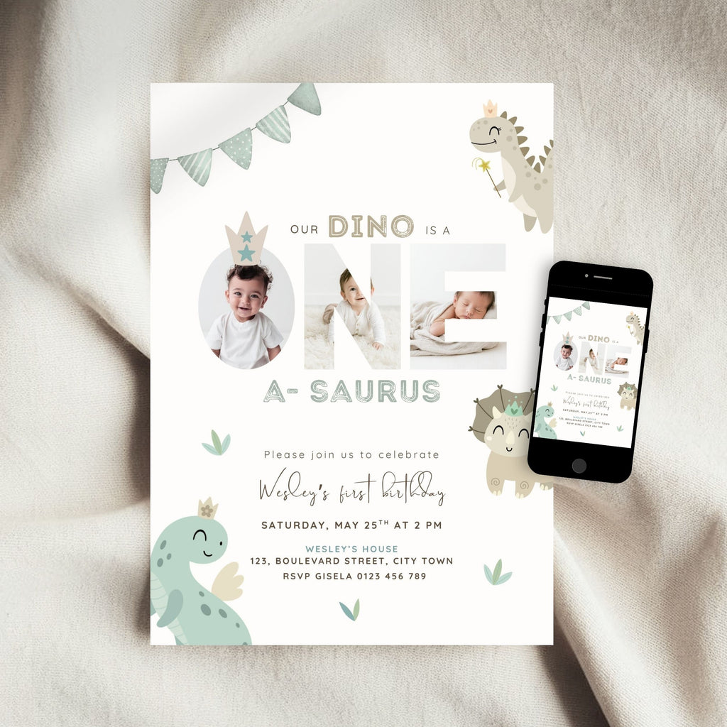 A baby dinosaur-themed first birthday invitation card displayed on a soft beige fabric background, with a smartphone showing the digital version of the invitation beside it.