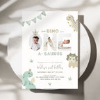 A children's first birthday invitation card with a dinosaur theme, styled flat on a round white plate with soft shadows. The card features the text 'OUR DINO IS A NE A-SAURUS' with photo placeholders, cute pastel dinosaur illustrations, and event details.