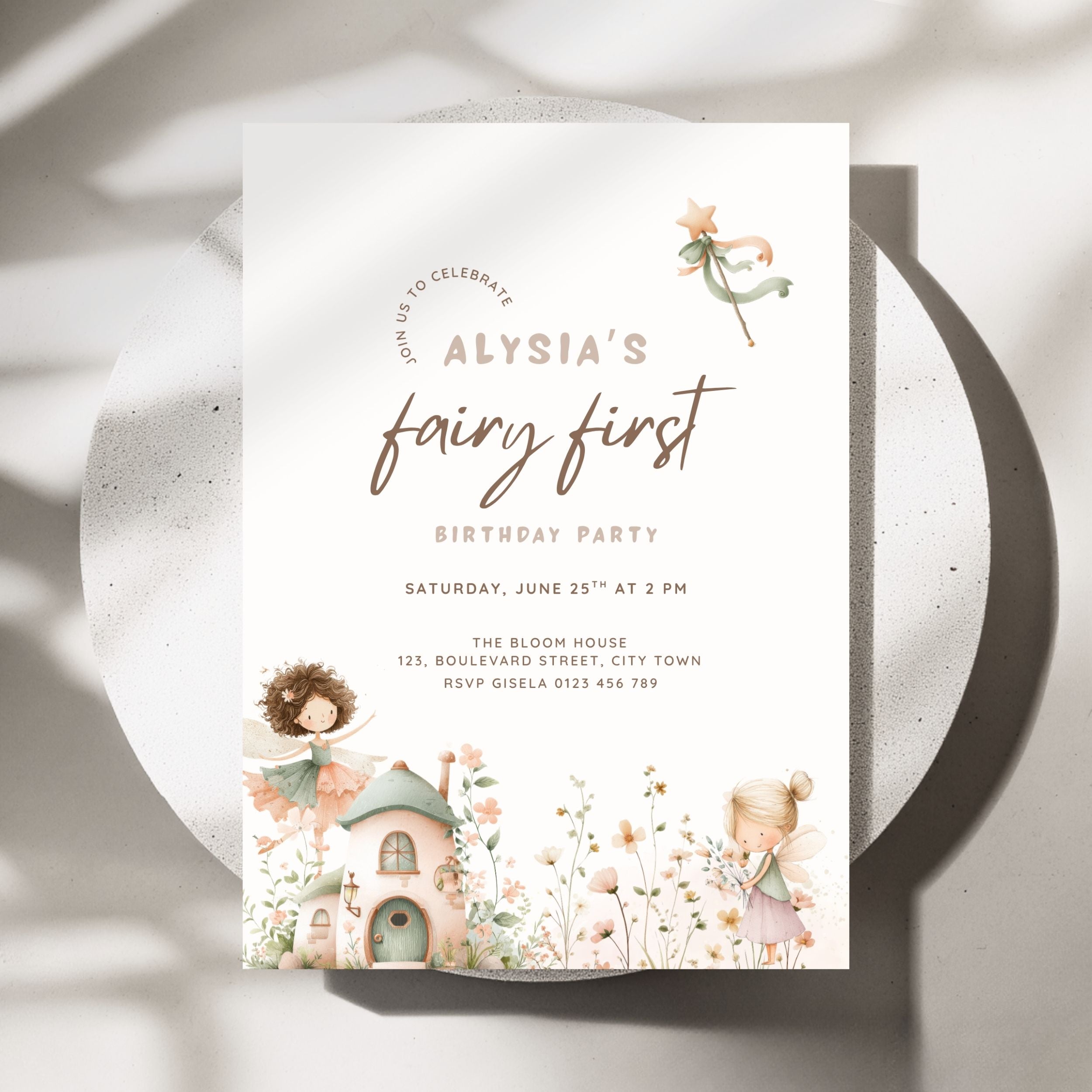 A vertical fairy-themed first birthday party invitation card displayed on a round white plate with soft shadows. The card features elegant script text reading 'Alysia's fairy first birthday party' with watercolor illustrations of fairies, a small cottage, and wildflowers in soft pastel tones.