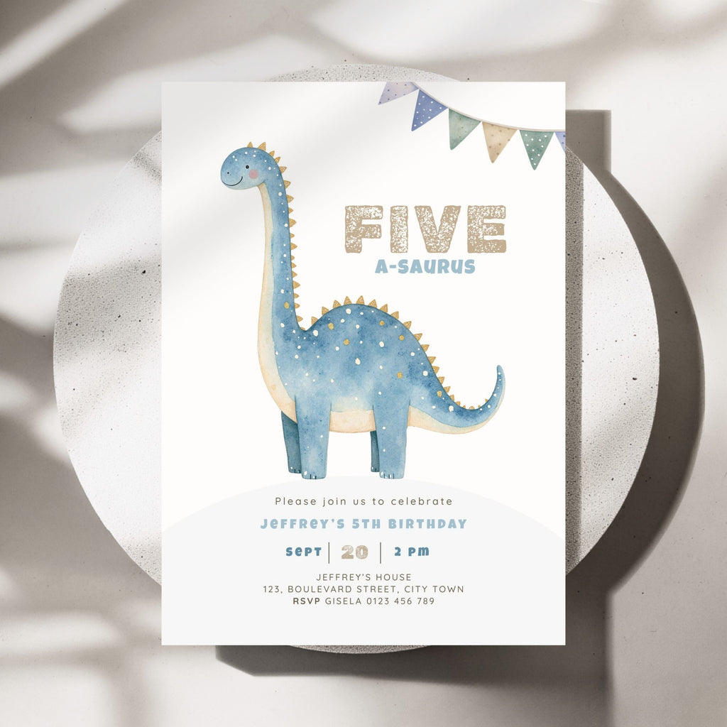 A children's 5th birthday invitation card featuring a blue watercolor long-neck dinosaur and the text 'FIVE A-SAUROS' in gold glitter-style lettering, styled on a round white tray with soft shadows.