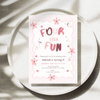 A square birthday invitation card with a pink and white striped border and floral accents, reading 'FOUR EVER FUN' in large pink letters. The card is photographed on a round speckled tray with soft leaf shadows cast across the scene.