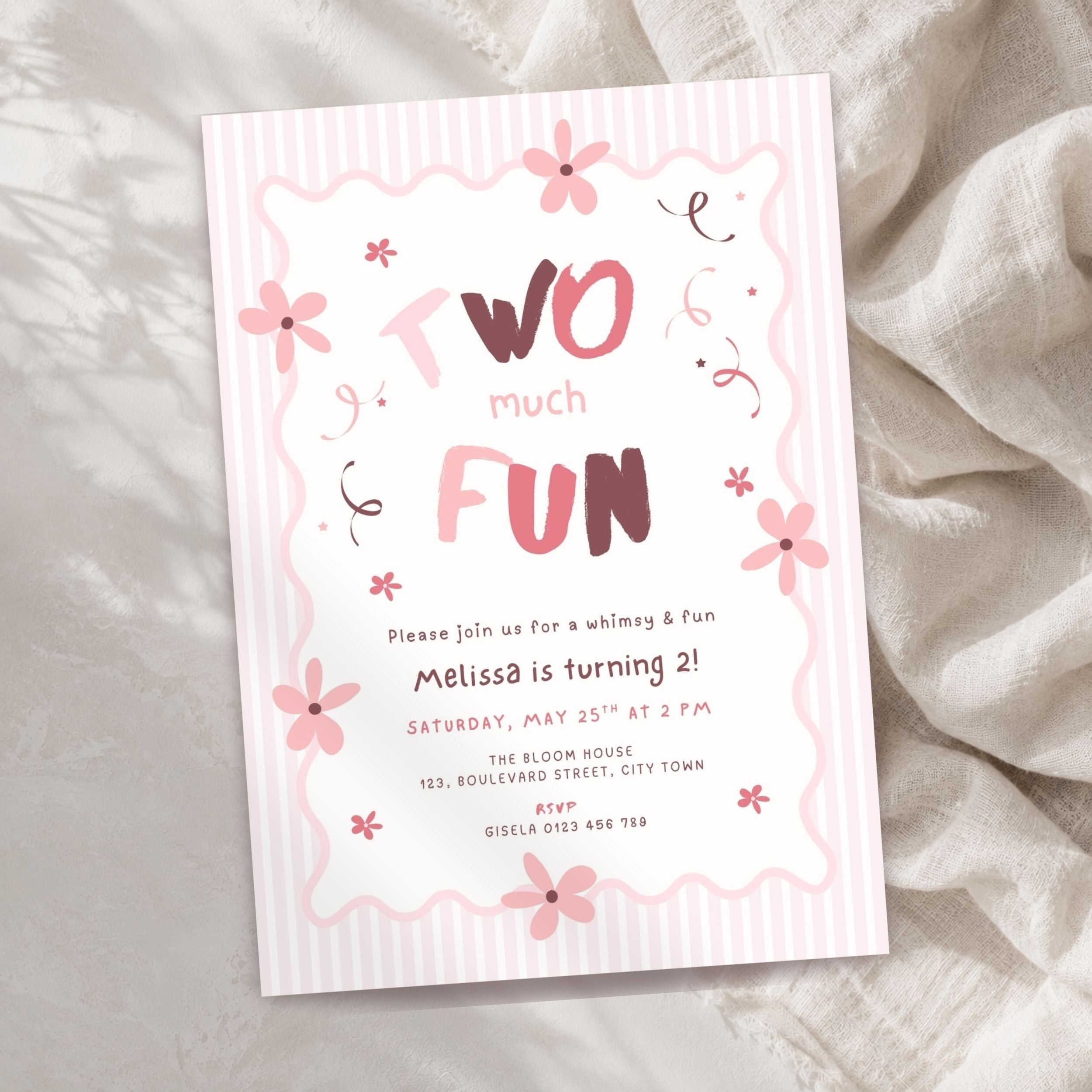 A pink and white striped children's birthday invitation card with floral illustrations and the text 'Two much FUN,' styled on a soft beige fabric background.