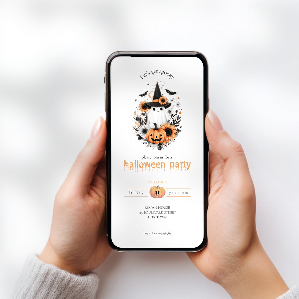 A person holds a smartphone with a Halloween party invitation displayed on the screen. The design features a witch hat, pumpkins, bats, and orange floral accents on a white background.