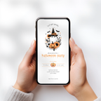 A person holds a smartphone with a Halloween party invitation displayed on the screen. The design features a witch hat, pumpkins, bats, and orange floral accents on a white background.