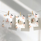 Three personalized Halloween photo cards clipped to a string against a white wall, decorated with cute cartoon illustrations of ghosts, bats, and cupcakes.