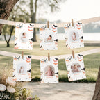 Six personalized baby milestone photos clipped to two horizontal wooden clotheslines outdoors between tree trunks, with a blurred park background and white flowers at the lower left.