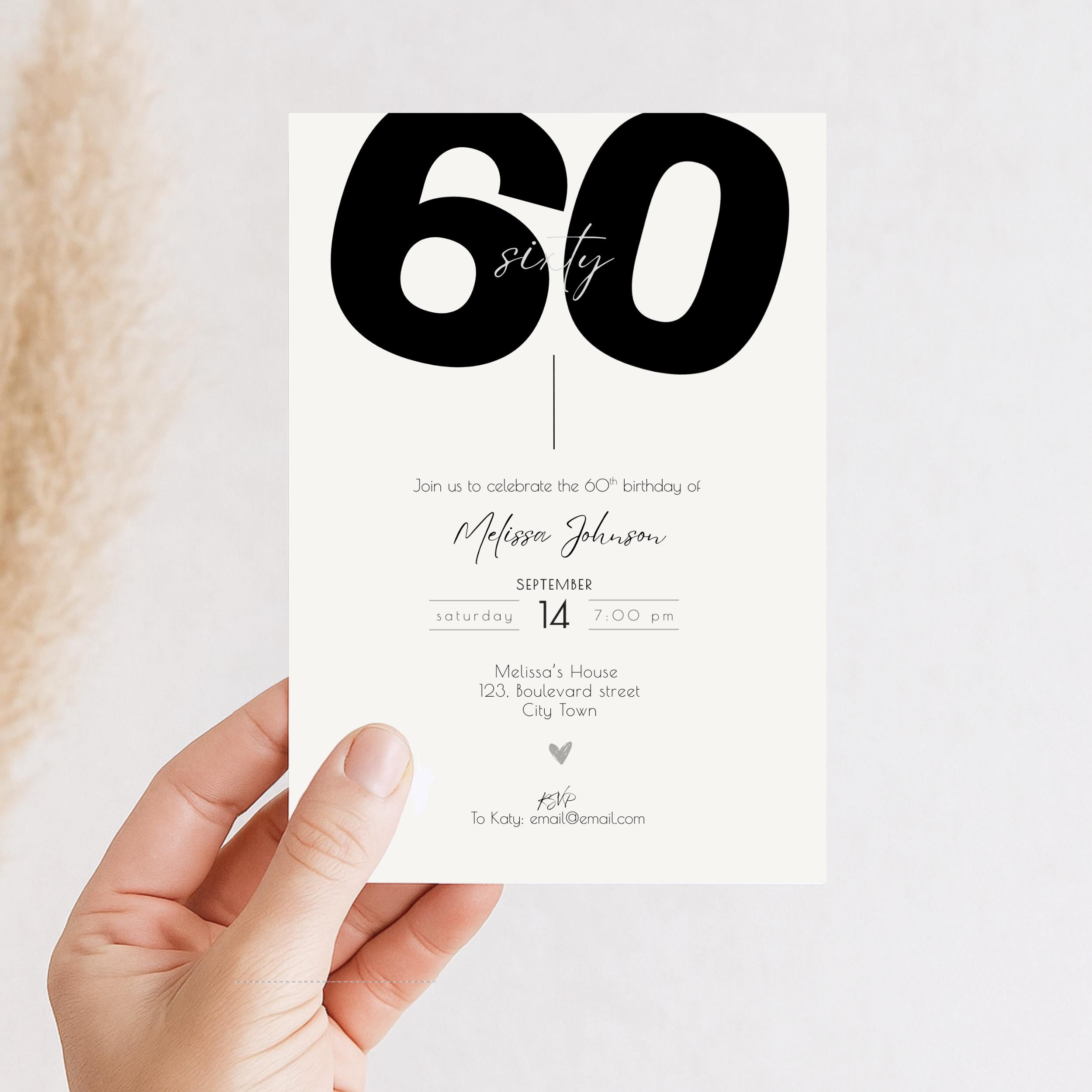 Hand holding a 60th birthday invitation card with '60' on it