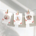 Three white baby milestone photos hanging from a string with wooden clothespins against a white wall. Each card has a circular photo of a baby, watermelon slice illustrations, and the date '5 Months' written in pink script.