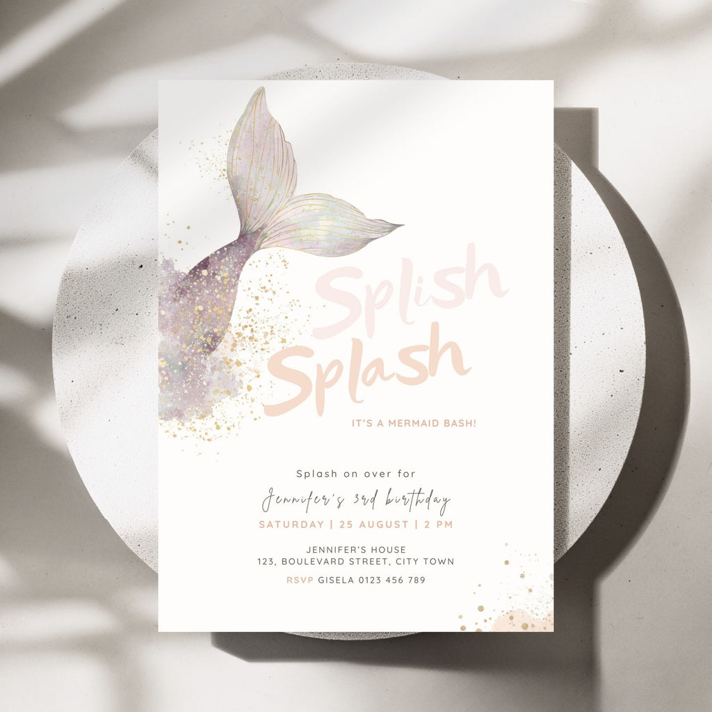 A mermaid-themed birthday invitation card displayed on a round white plate with soft shadows. The card features a pastel watercolor mermaid tail, gold glitter accents, and the words 'Splash Splash' in a light pink script font.