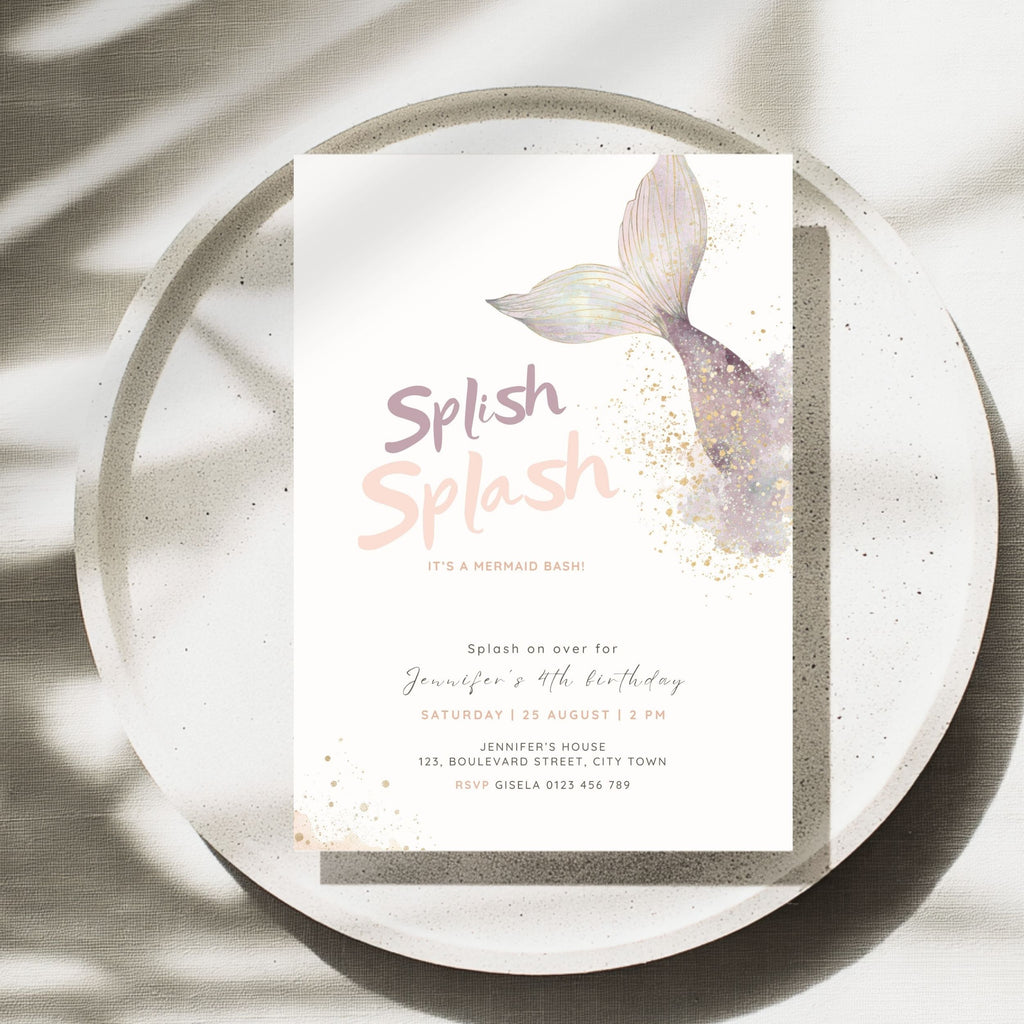 A mermaid-themed birthday invitation card displayed on a speckled white ceramic plate with soft leaf shadows. The card features a watercolor mermaid tail in lavender and purple, gold glitter accents, and the text 'Splash Splash' in a pink and mauve font.