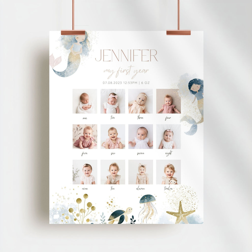 A personalized baby first-year photo calendar poster hanging from two copper clips against a light gray wall. The white poster features the name 'JENNIFER' and 'my first year' in elegant typography, a grid of 12 baby photos from infancy, and whimsical watercolor illustrations of a mermaid, jellyfish, starfish, and sea life in soft pastel tones.