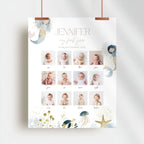 A personalized baby first-year photo calendar poster hanging from two copper clips against a light gray wall. The white poster features the name 'JENNIFER' and 'my first year' in elegant typography, a grid of 12 baby photos from infancy, and whimsical watercolor illustrations of a mermaid, jellyfish, starfish, and sea life in soft pastel tones.
