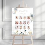 A personalized baby first-year photo timeline sign displayed on a wooden easel. The white sign features the name 'JENNIFER', 'my first year', and a grid of baby photos with labels.
