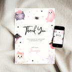 A Halloween-themed 'Thank You' card with cute watercolor illustrations of a ghost, cauldron, spider, and mushrooms, displayed next to a smartphone showing the same design on a soft white fabric background.