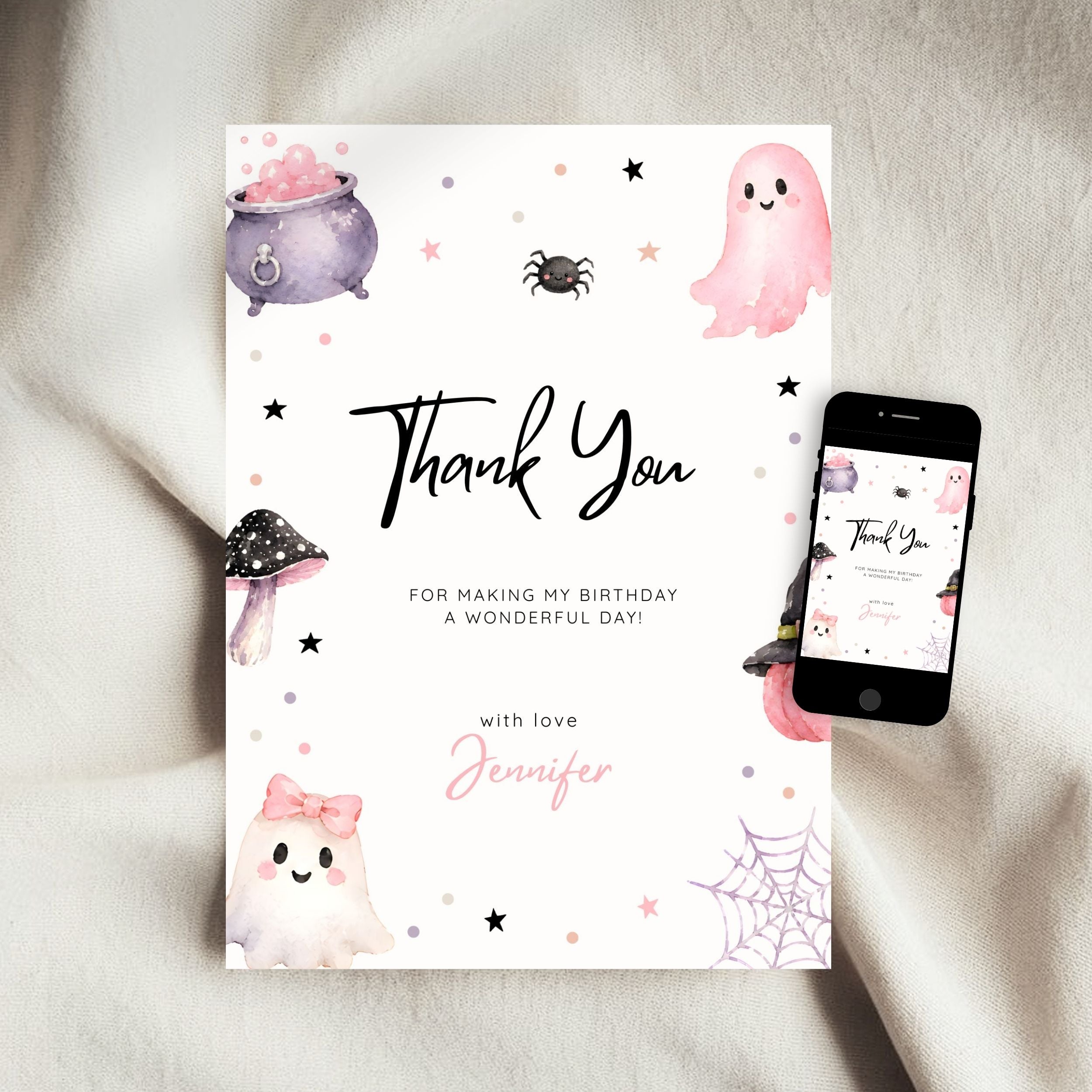 A Halloween-themed 'Thank You' card with cute watercolor illustrations of a ghost, cauldron, spider, and mushrooms, displayed next to a smartphone showing the same design on a soft white fabric background.