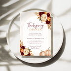 Thanksgiving dinner invitation template with burgundy and orange floral arrangements, pumpkins, wheat accents, elegant typography, and autumn-inspired details on a cream background.