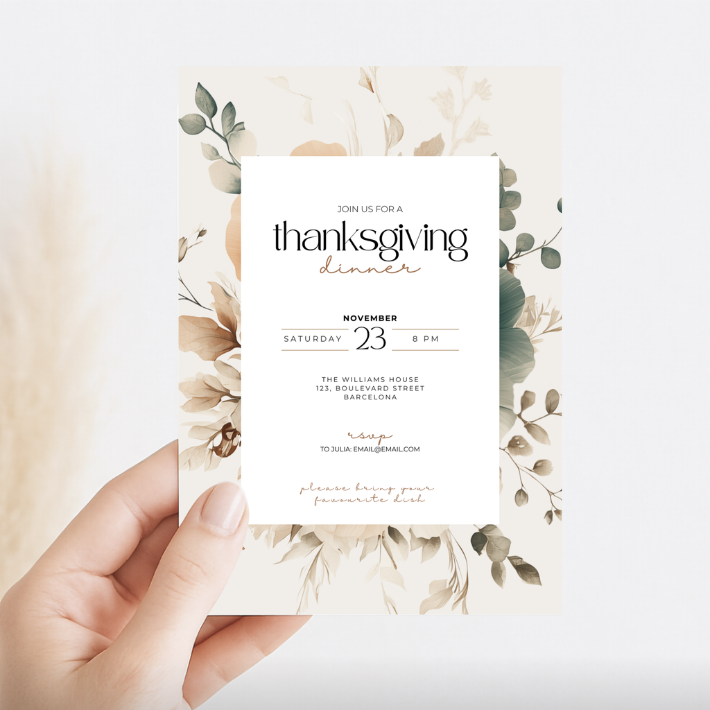 A hand holds a square floral invitation card with elegant typography reading 'thanksgiving dinner' and event details, set against a soft light background.