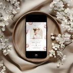 Phone displaying a 2nd birthday invitation on a wooden plate with white flowers