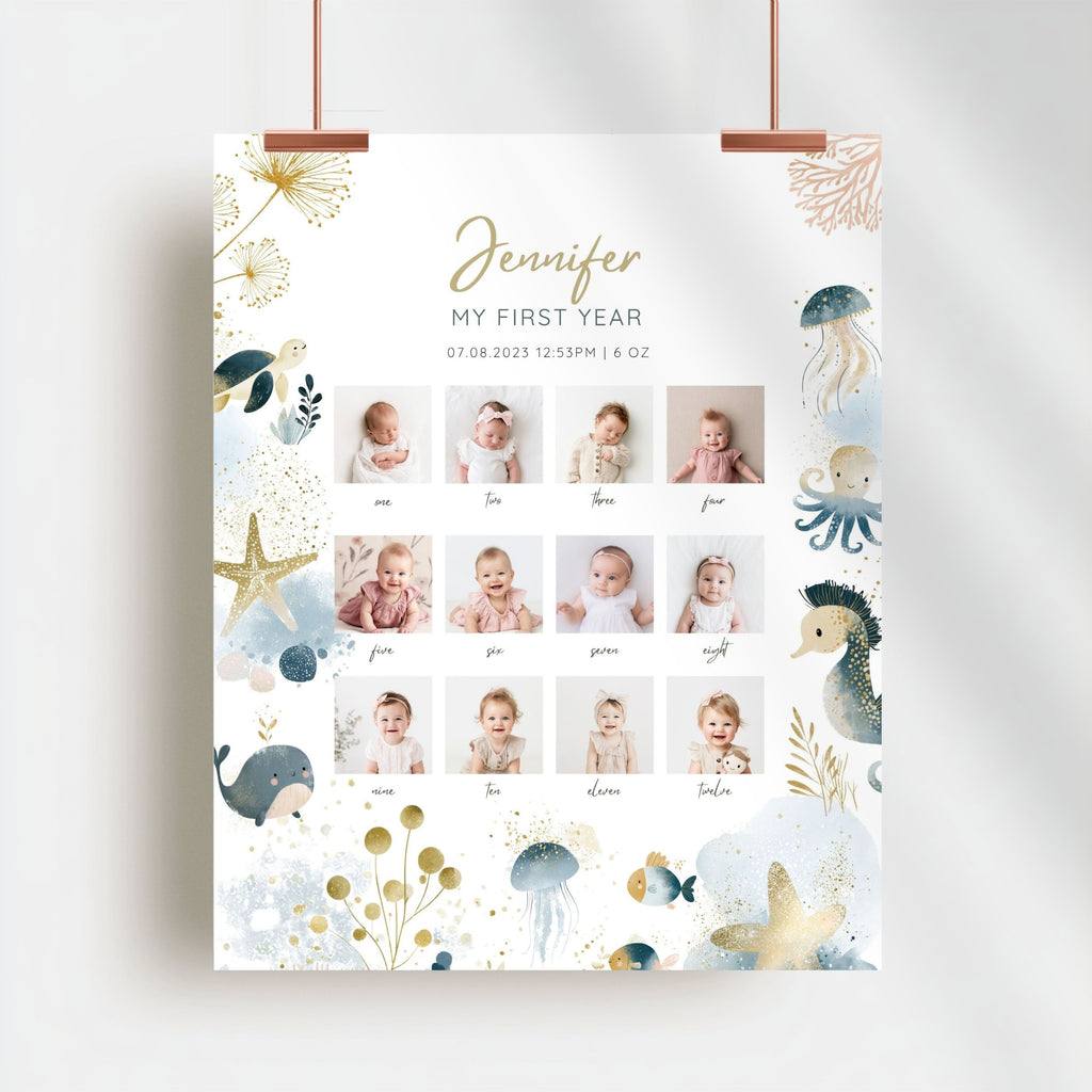 A personalized baby first year photo poster hanging from two copper clips against a white wall. The poster features a white background decorated with watercolor-style sea creatures like a whale, octopus, seahorse, and starfish in blue, gold, and beige.