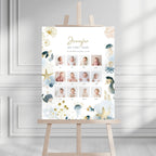 A personalized first-year baby photo gallery sign with an ocean-themed watercolor design, displayed on a wooden easel in a bright, modern room.