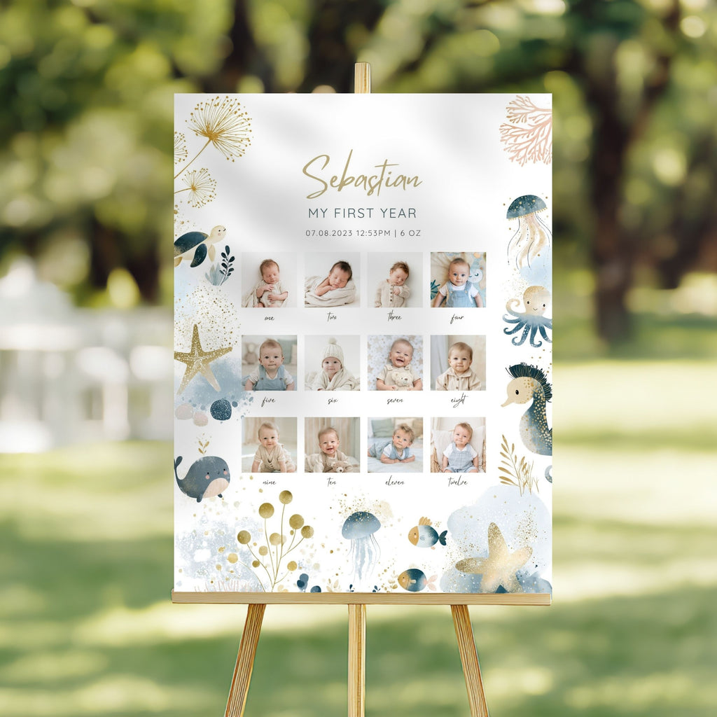 A personalized first birthday photo collage sign with an ocean-themed design, displayed on a wooden easel in an outdoor garden setting.